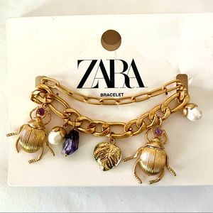 Zara gold double chain bracelet adorned with pearl, amethyst and bug charms